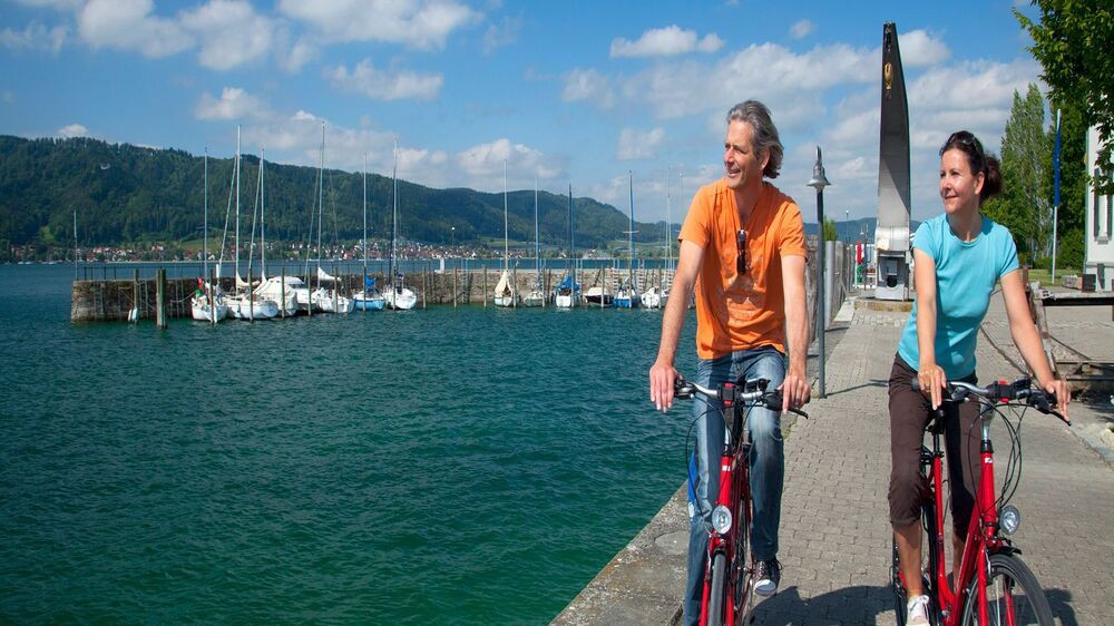 Couple cycling along the harbour of Lake Constance - Germany