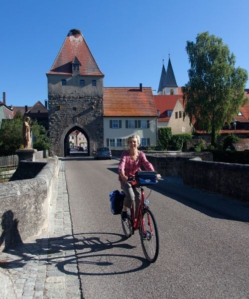 Cyclist on the medieval bridge of Herrieden - Bavaria - Germany