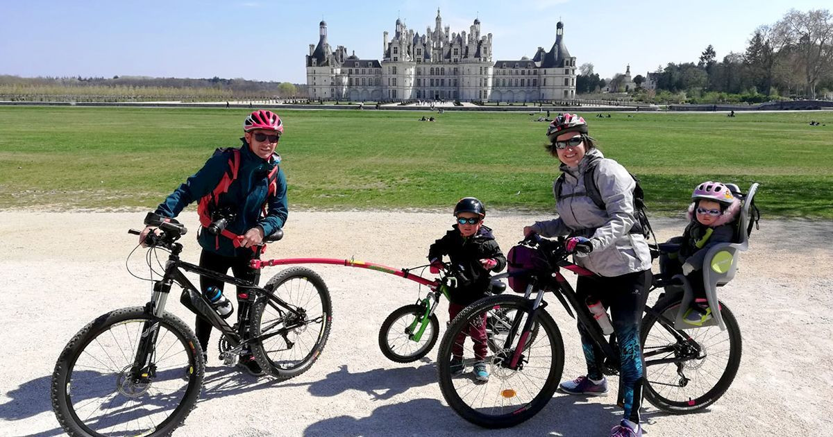 Family cycling before the Château de Chambord - Loire Valley - France