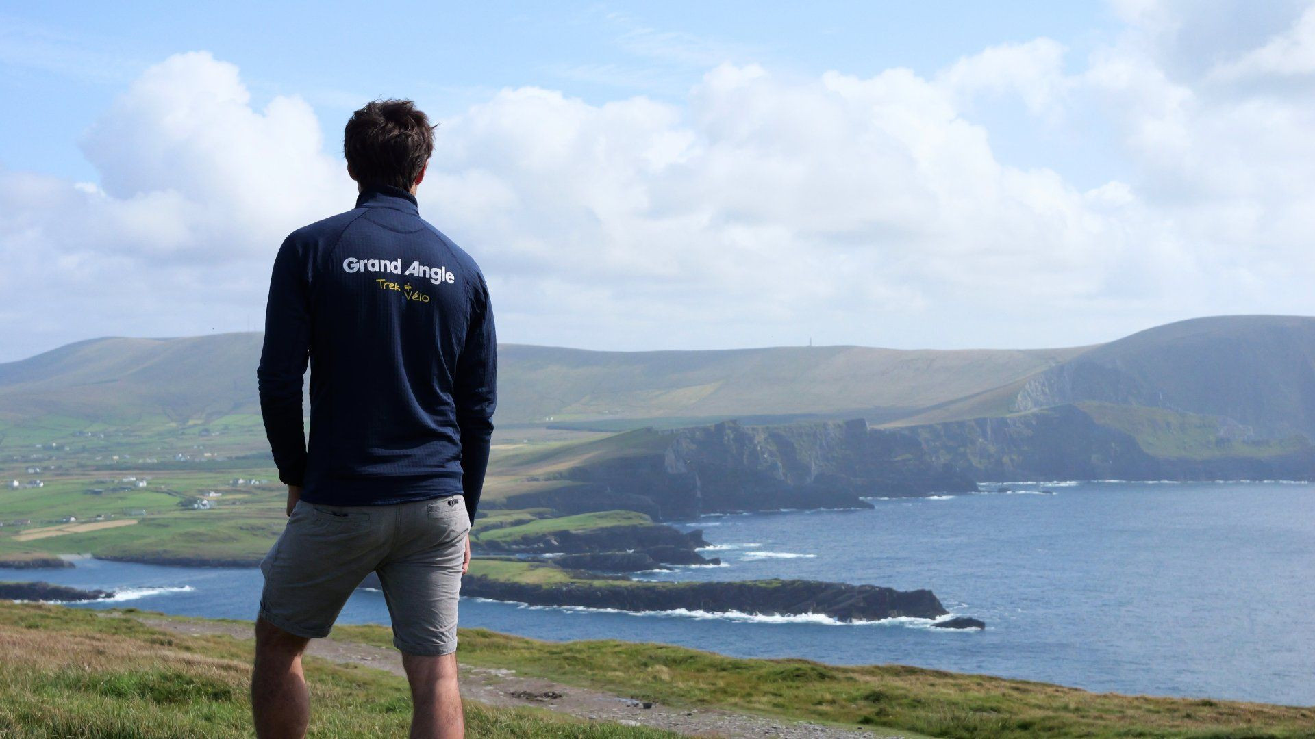 Hiker facing the coastal cliffs - Ring of Kerry - Ireland