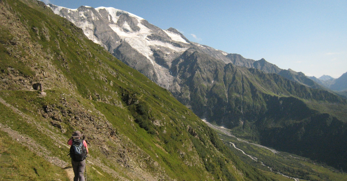 Hiker facing the Bionnassay glacier, Col du Tricot - Tour du Mont Blanc - Alps