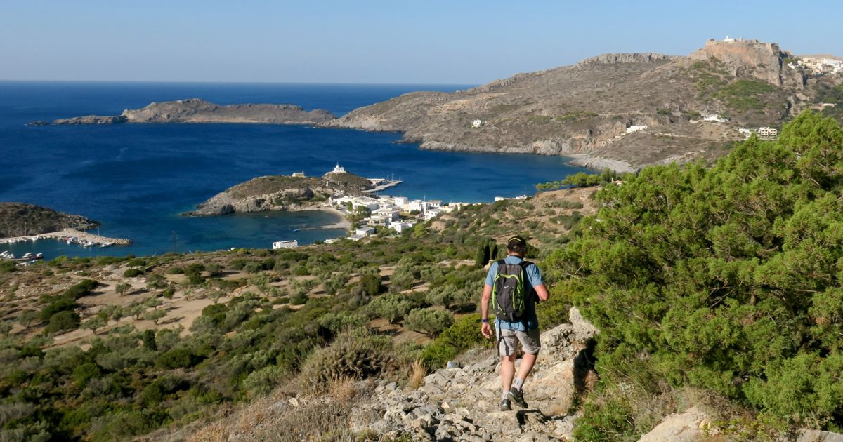 Hiker overlooking a turquoise bay - Kythira Island - Greece