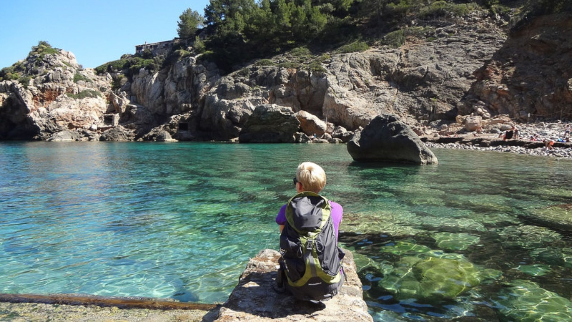 Hiker resting by a turquoise cove - Mallorca - Spain
