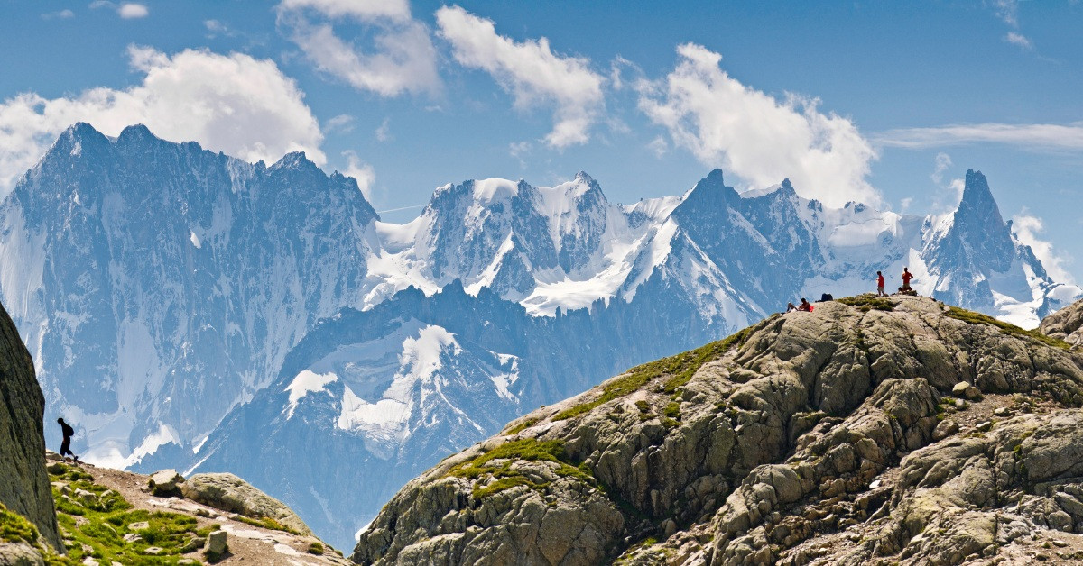 Hikers at a summit facing the Mont Blanc massif - Alps - France