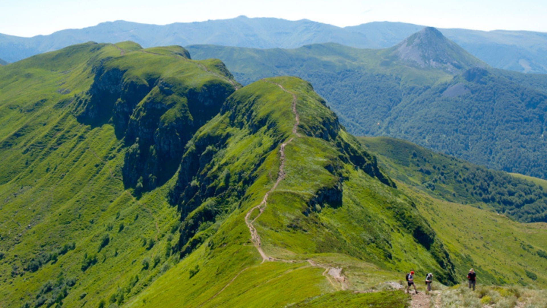 Hikers on a ridge trail - Cantal mountains - Auvergne, France