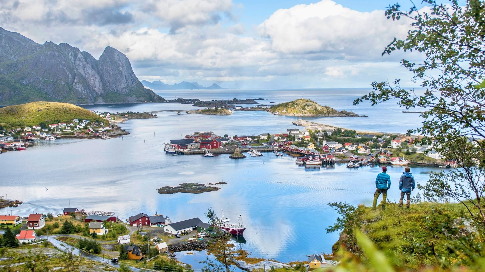 Hikers overlooking a fishing village - Lofoten Islands - Norway
