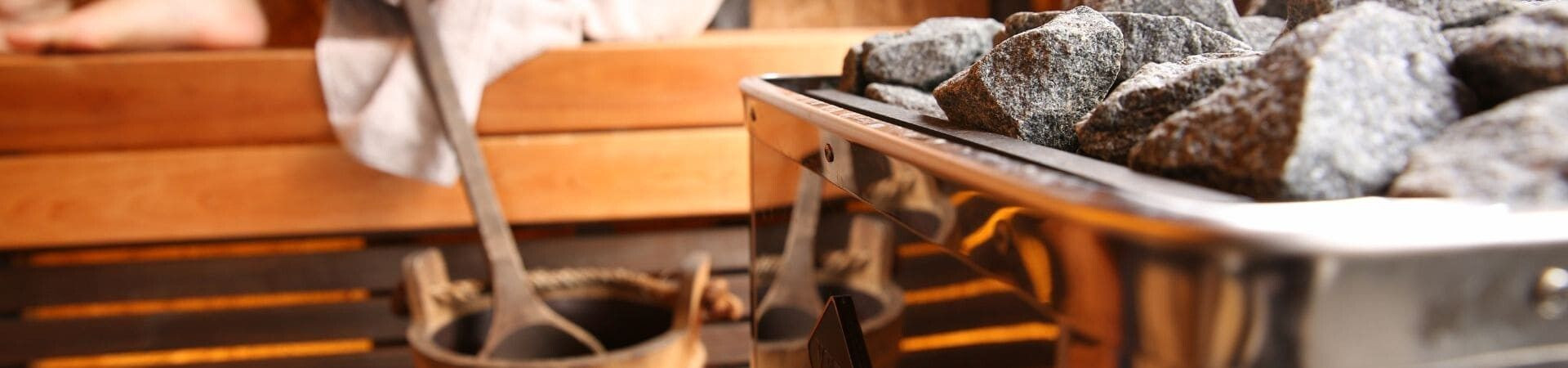 Hot stones and wooden bucket in a sauna - Wellness area