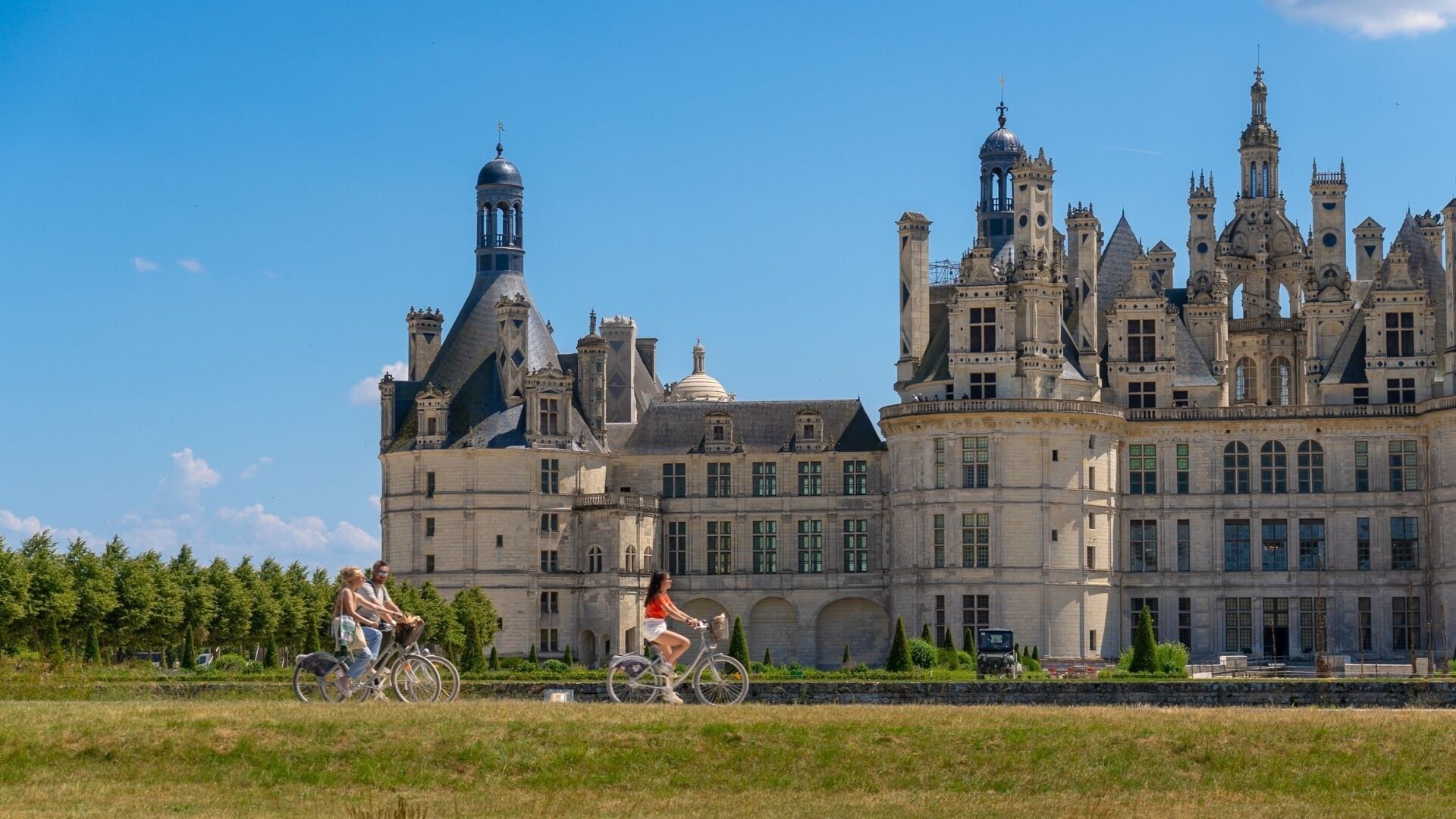 Cyclists riding past Château de Chambord - Loire Valley - France
