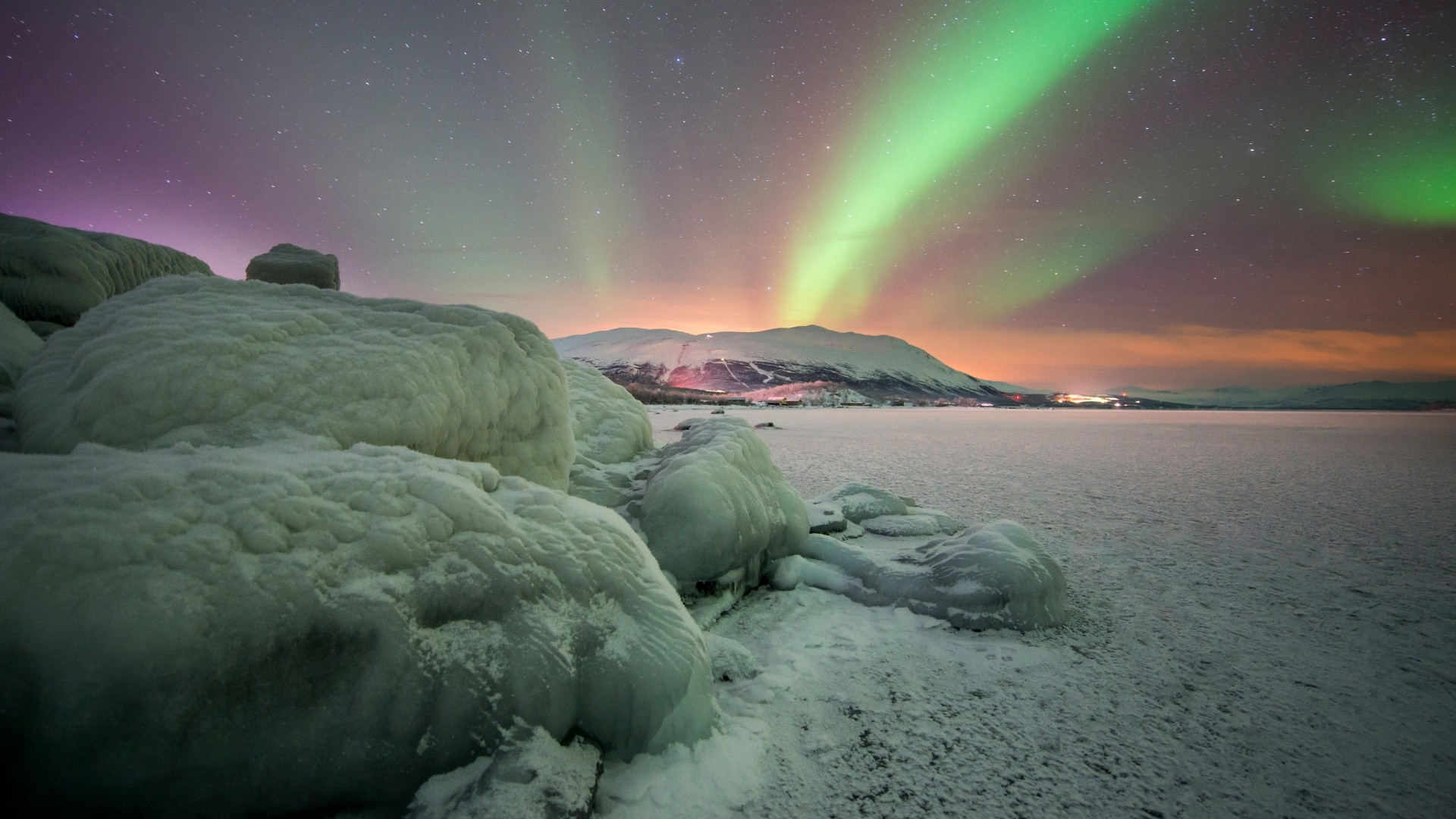 Northern lights over a snowy frozen lake - Sweden