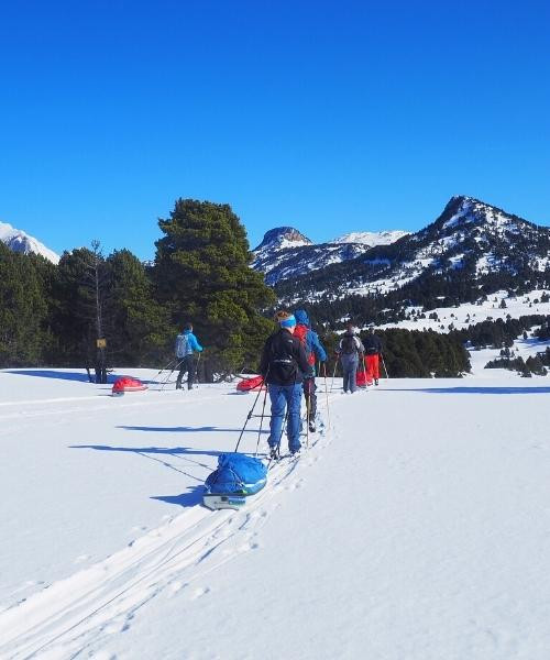 Groupe de ski de randonnée avec pulkas sur plateau enneigé - Pyrénées - France