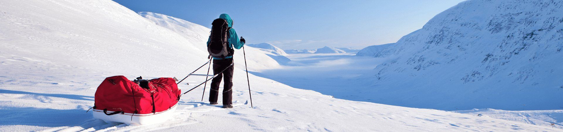 Skier pulling a pulka sled across a snowy landscape - Lapland - Sweden