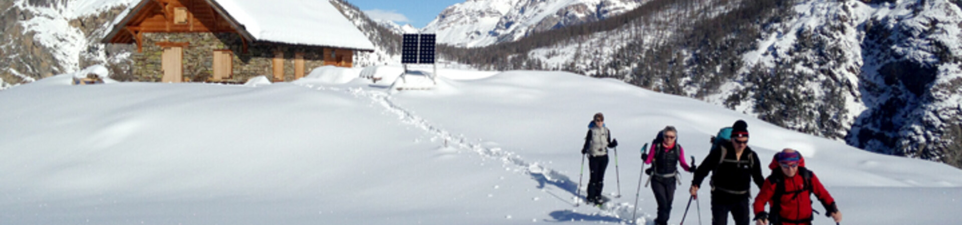 Snowshoers near a mountain chalet - Écrins - France