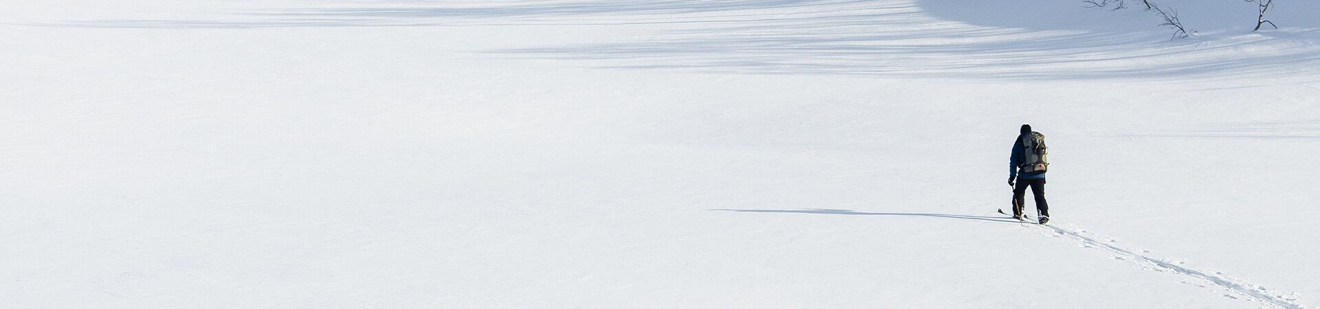 Solo skier crossing a vast snowy plain - Nordic ski touring