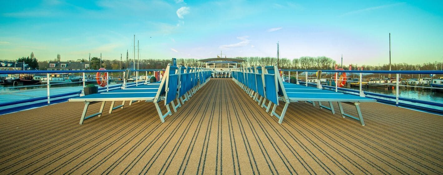 Sun deck and blue deckchairs of the MS Olympia riverboat at port - river cruise