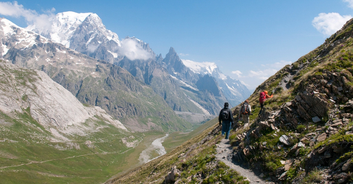 Hikers on the trail facing the Mont Blanc massif - Val Ferret - Italy