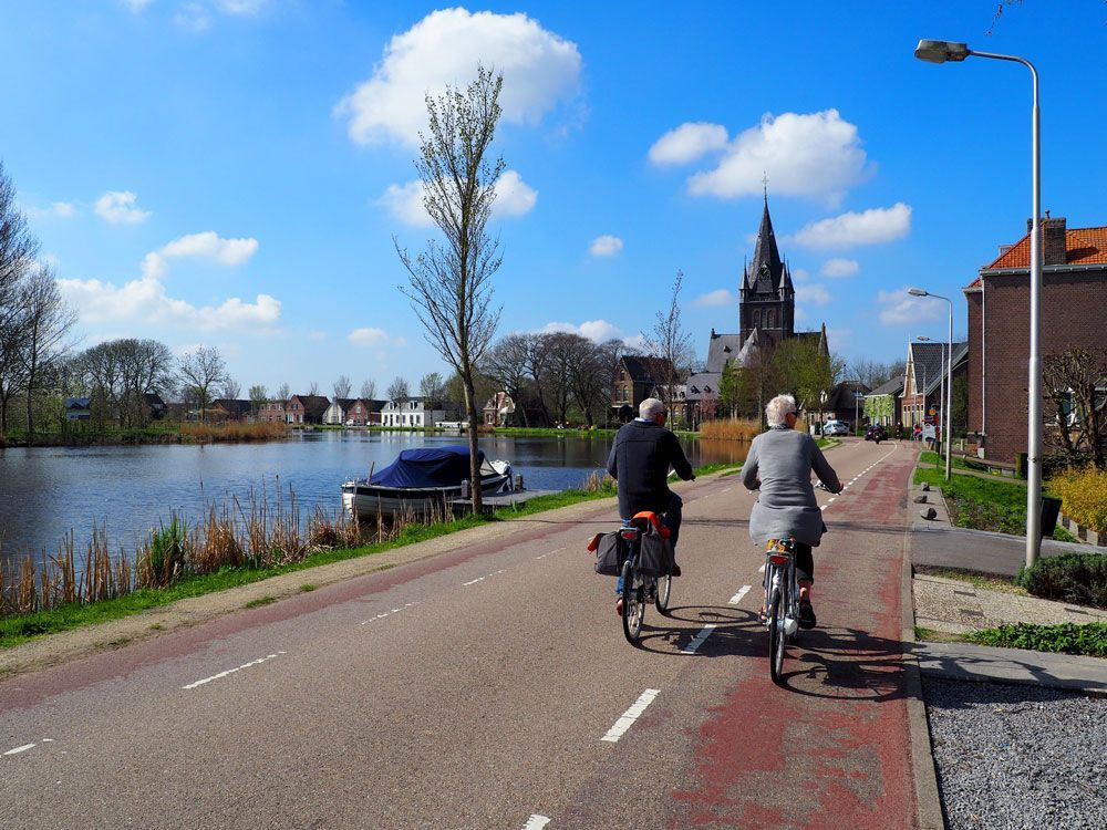 © David Praire Cycling along the canalised River Amstel in the Netherlands © David Praire