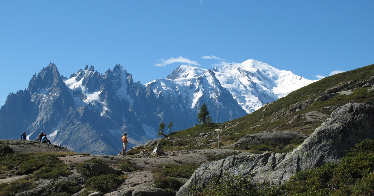 Hiker facing the Aiguilles and the Mont Blanc massif - Alps - France
